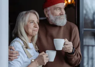 couple regardant dehors en tenant des tasses